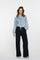 Geisha Fashion: Person wearing denim shirt, black pants in studio.
